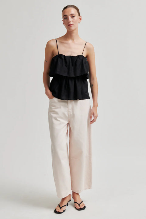 Second Female Aie Top Black - Side Profile Highlighting Tiered Hem and Lightweight Linen Drape