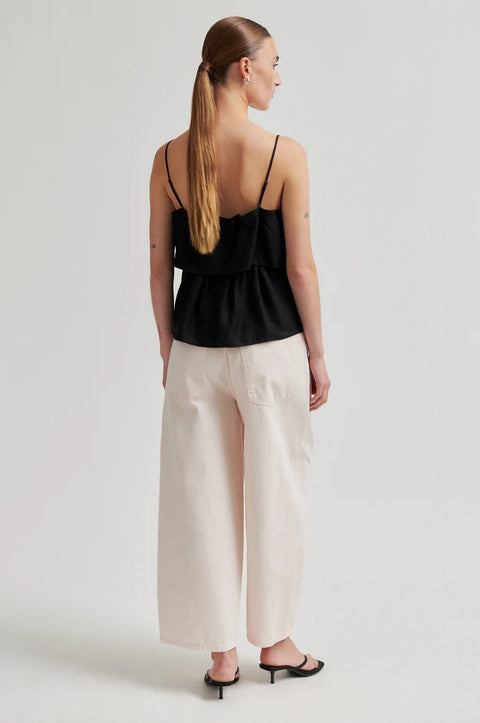 Second Female Aie Black Tiered Top - Styled Shot Showing Relaxed Elegant Fit