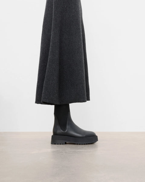 Platform black leather boots with knit paneling up the ankle, pull on style. Made by flattered. rubber sole and leather upper