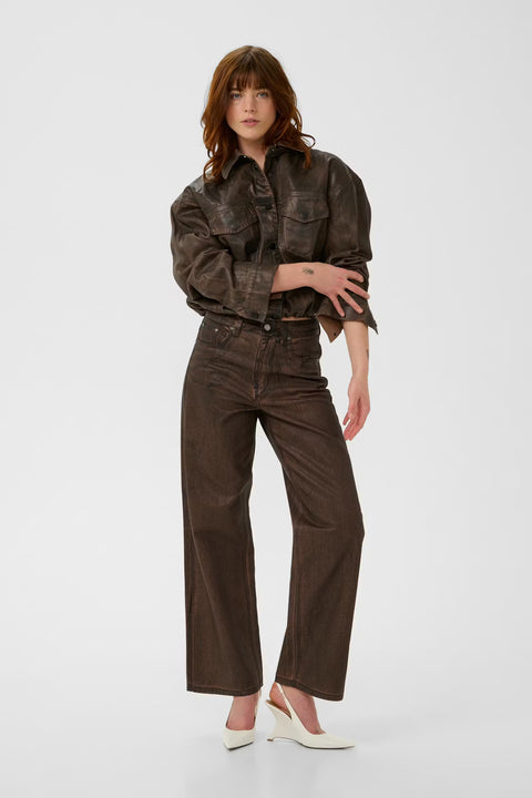 Chocolate brown coated denim jacket with a vintage waist-length cut, puckered hem, and snap buttons.