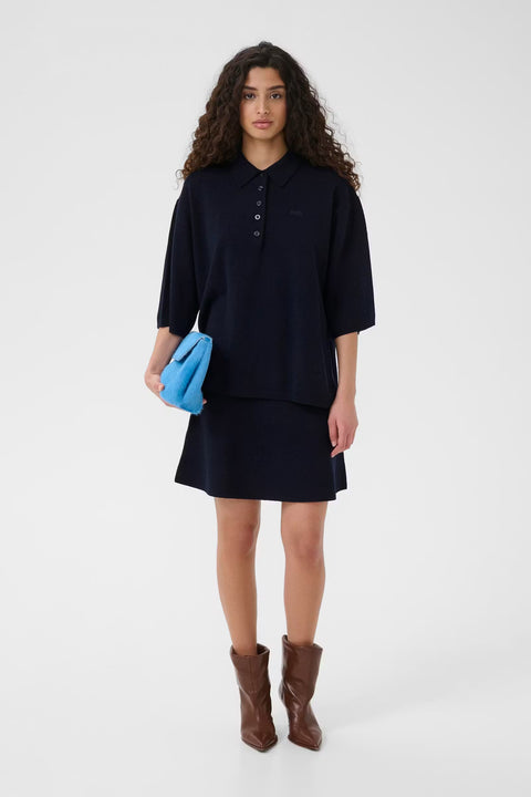 Black wool knit polo shirt with a boxy silhouette, dropped shoulders, five-button placket, and elbow-length wide sleeves.