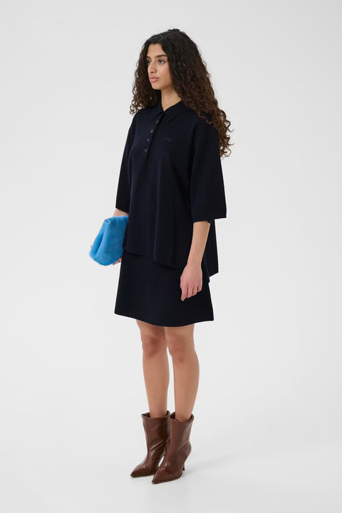 Black wool knit polo shirt with a boxy silhouette, dropped shoulders, five-button placket, and elbow-length wide sleeves.