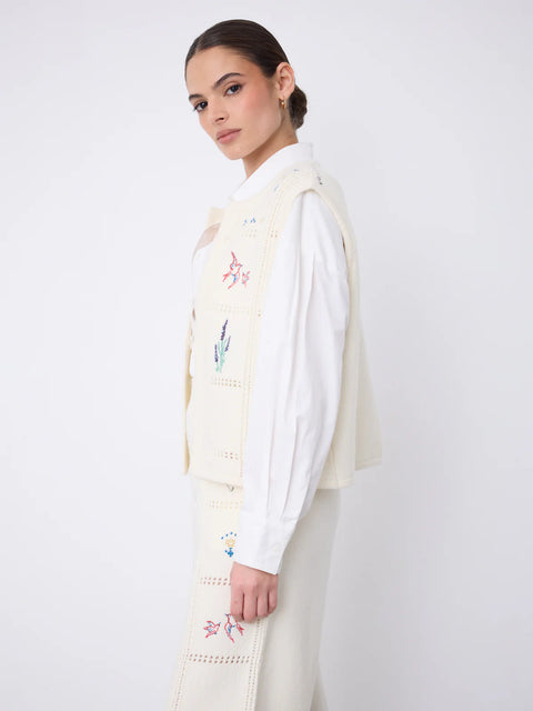 Notshy Lali Vest in Ecru – sleeveless wool and cashmere crochet vest with patchwork knit texture, single button detail and large floral embroidery on the back