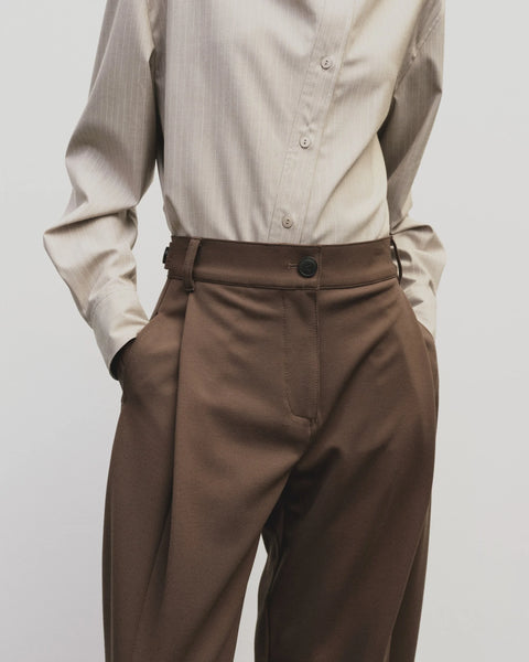 High-waisted, barrel-legged pants. Pleat detail at the hip and side seam pockets, pants cut at ankle.Mijeong Park Pleated Barrel-Leg Pants in Brown