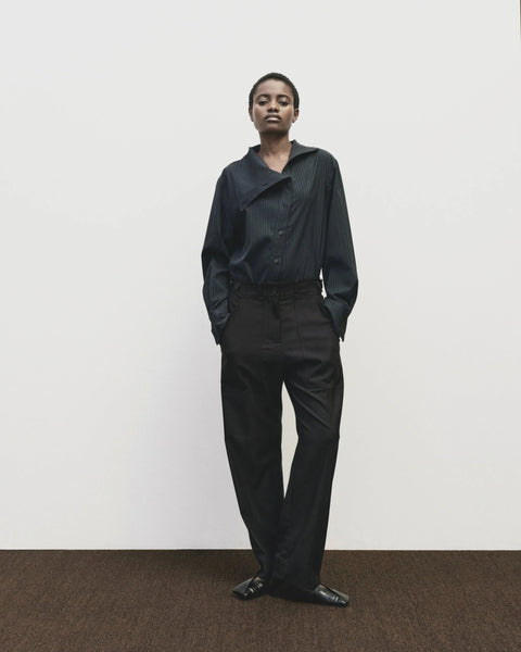 Relaxed fit pants with straight leg and oversized pockets. Buttons on the waist and cuff for adjustability. Navy blue. Trouser by Mijeong Park