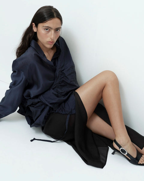 Black organza wrap skirt styled seated outfit relaxed elegant look