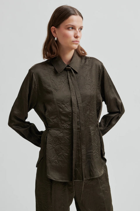 classic blouse cut from crinkle fabric, in dark olive colour. regular collar and concealed button placket, detachable neck tie and side-waist buttons to nip the waist for an adjustable silhouette