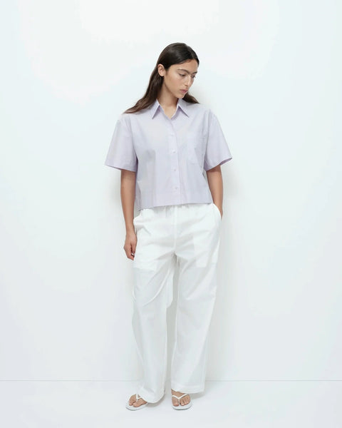 Purple short sleeve cotton shirt full outfit styled with white pants.