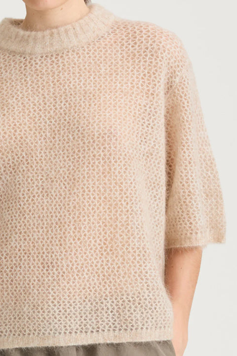straight silhouette and a refined dropped shoulder, short sleeve sweater, relaxed sleeves finished with a subtle rib and finished with a rounded neckline. Mohair