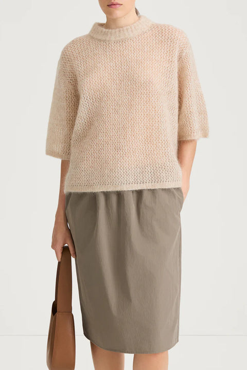 straight silhouette and a refined dropped shoulder, short sleeve sweater, relaxed sleeves finished with a subtle rib and finished with a rounded neckline. Mohair