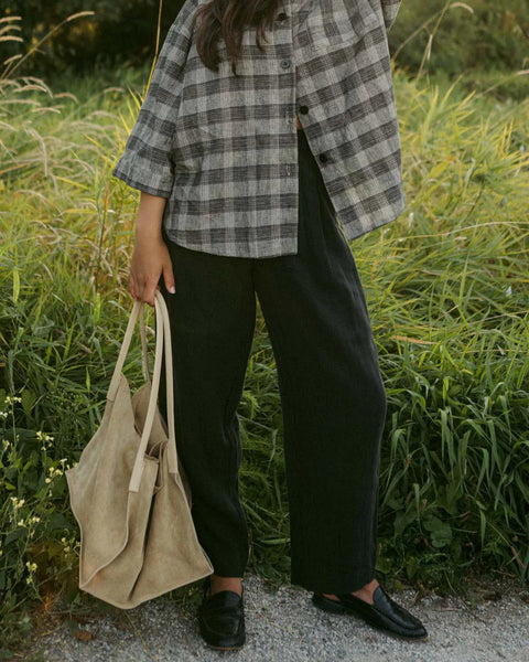 A pair of Thorne Trousers in 100% linen twill featuring a comfortable three-quarter elastic waistband, front pleats, and a vintage-inspired shell button closure.