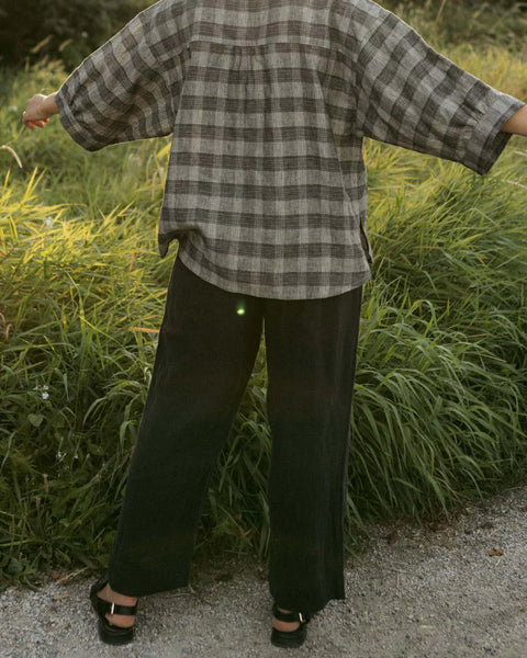 A pair of Thorne Trousers in 100% linen twill featuring a comfortable three-quarter elastic waistband, front pleats, and a vintage-inspired shell button closure.