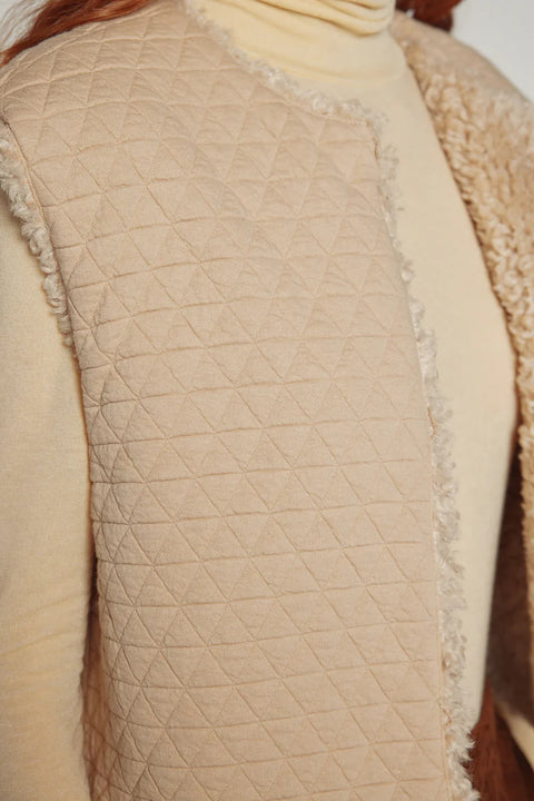 Woman wearing Amente reversible vest, one side faux fur oatmeal, other side cotton beige
