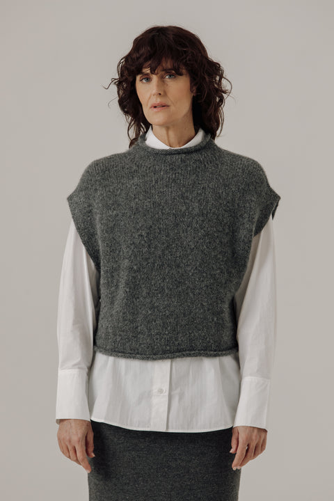 Sweater vest in grey, boxy fit, hits at waist, made of merino wool and has a mock neckline, brand is Bare Knitwear
