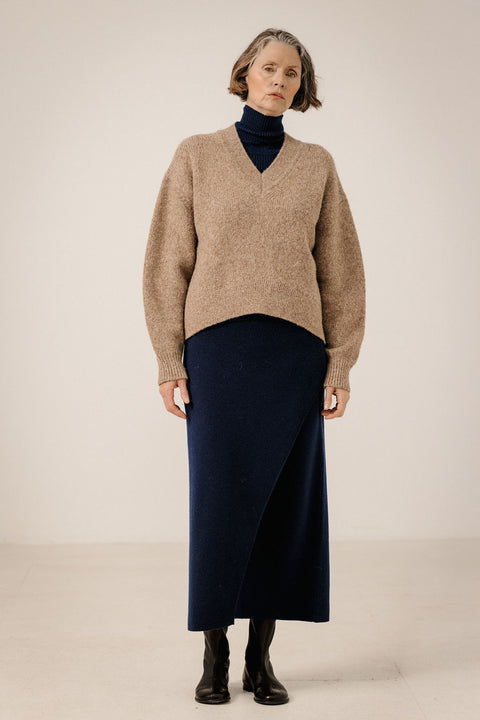 Bare Knitwear Boxy V-Neck Dark Fawn - Side View Highlighting Curved High-Low Hem and Relaxed Layering Silhouette