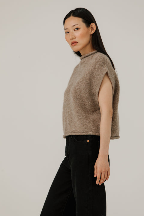 Sweater vest in beige, boxy fit, hits at waist, made of merino wool and has a mock neckline, brand is Bare Knitwear
