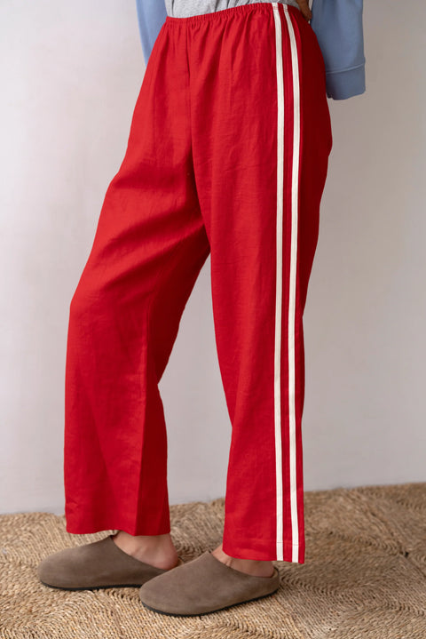 lightweight linen cropped pants in red with double white strip down the leg. Elastic waistband and cropped inseam and a wide leg fit. 