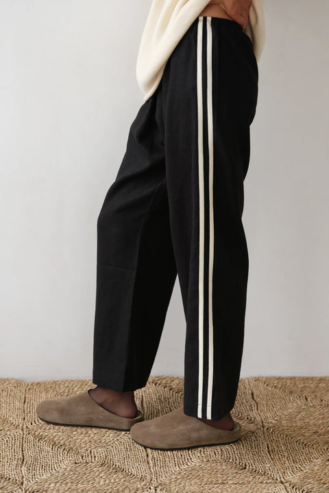 lightweight linen cropped pants in black with double white strip down the leg. Elastic waistband and cropped inseam and a wide leg fit. 