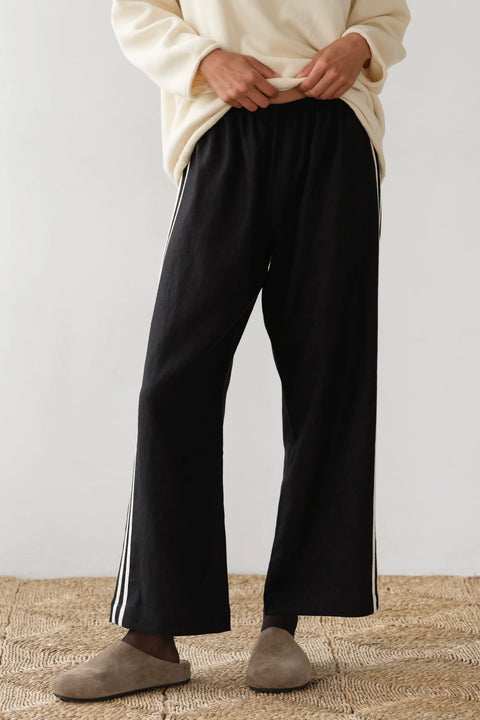 lightweight linen cropped pants in black with double white strip down the leg. Elastic waistband and cropped inseam and a wide leg fit. 