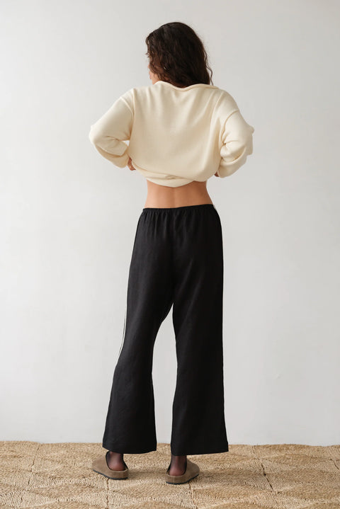 lightweight linen cropped pants in black with double white strip down the leg. Elastic waistband and cropped inseam and a wide leg fit. 
