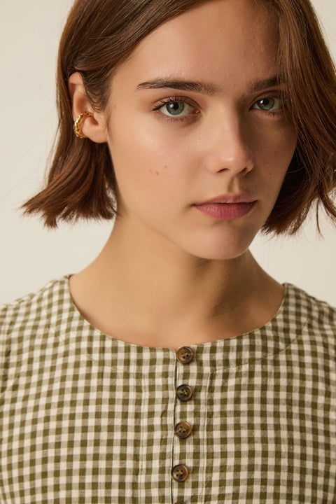 Gingham sleeveless top, retro style, cotton and linen blend, horn-effect buttons and designed to hit at the waist.
