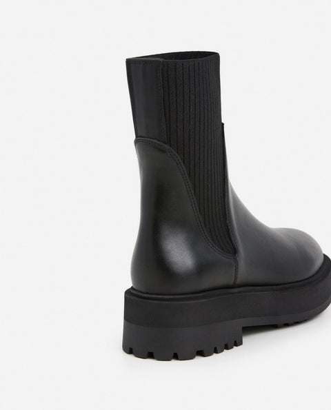 Platform black leather boots with knit paneling up the ankle, pull on style. Made by flattered. rubber sole and leather upper