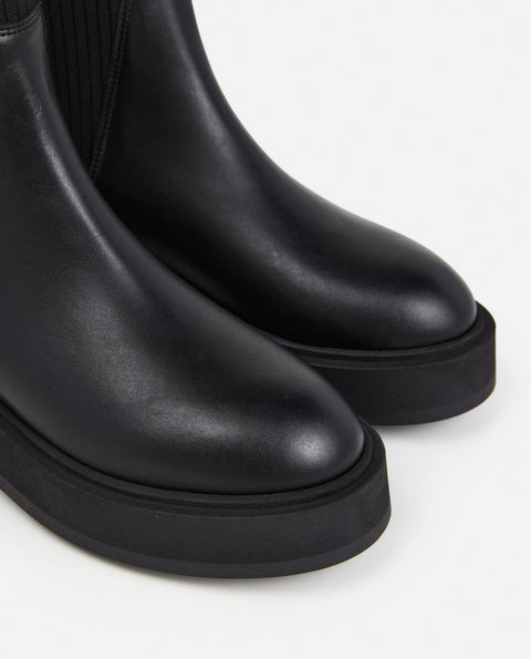Platform black leather boots with knit paneling up the ankle, pull on style. Made by flattered. rubber sole and leather upper