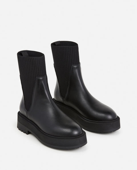 Platform black leather boots with knit paneling up the ankle, pull on style. Made by flattered. rubber sole and leather upper
