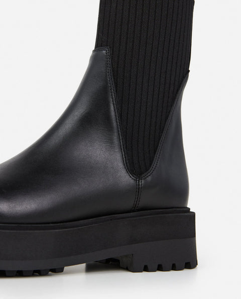 Platform black leather boots with knit paneling up the ankle, pull on style. Made by flattered. rubber sole and leather upper
