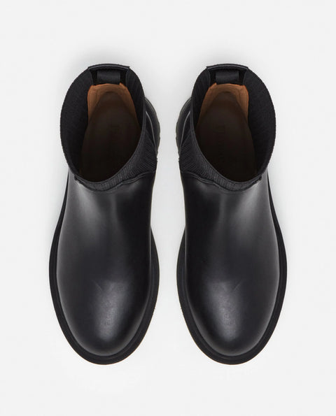 Platform black leather boots with knit paneling up the ankle, pull on style. Made by flattered. rubber sole and leather upper