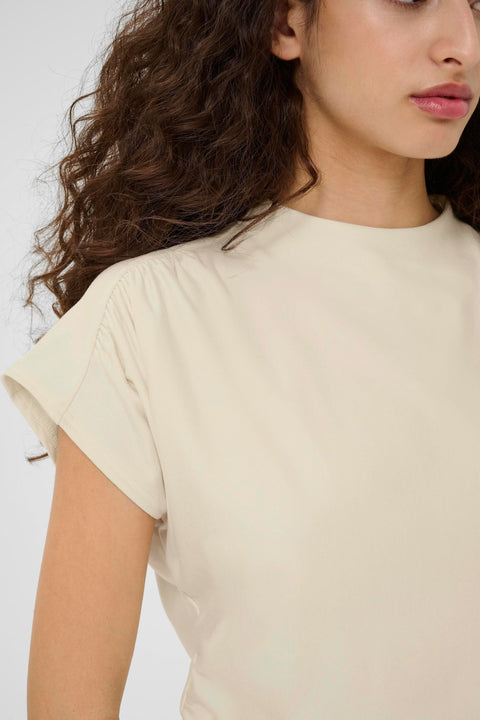 Classic minimalist cream mock neck top with cap sleeves. structured fabric. 
