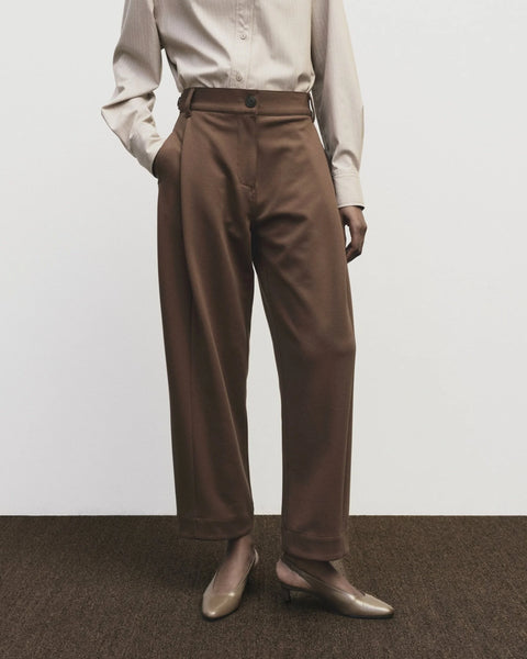 High-waisted, barrel-legged pants. Pleat detail at the hip and side seam pockets, pants cut at ankle.Mijeong Park Pleated Barrel-Leg Pants in Brown
