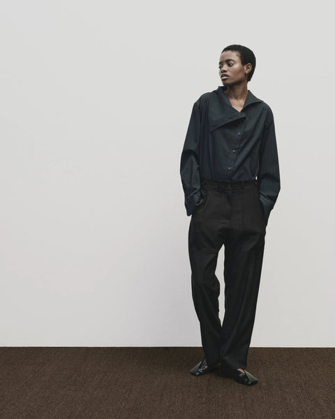 Relaxed fit pants with straight leg and oversized pockets. Buttons on the waist and cuff for adjustability. Navy blue. Trouser by Mijeong Park
