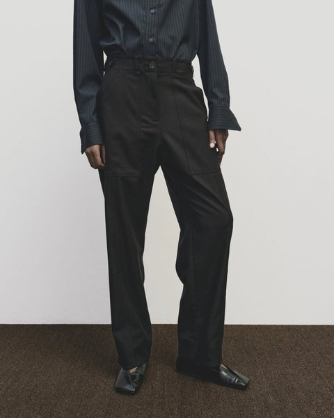 Relaxed fit pants with straight leg and oversized pockets. Buttons on the waist and cuff for adjustability. Navy blue. Trouser by Mijeong Park
