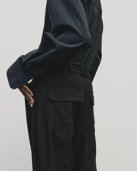 Relaxed fit pants with straight leg and oversized pockets. Buttons on the waist and cuff for adjustability. Navy blue. Trouser by Mijeong Park
