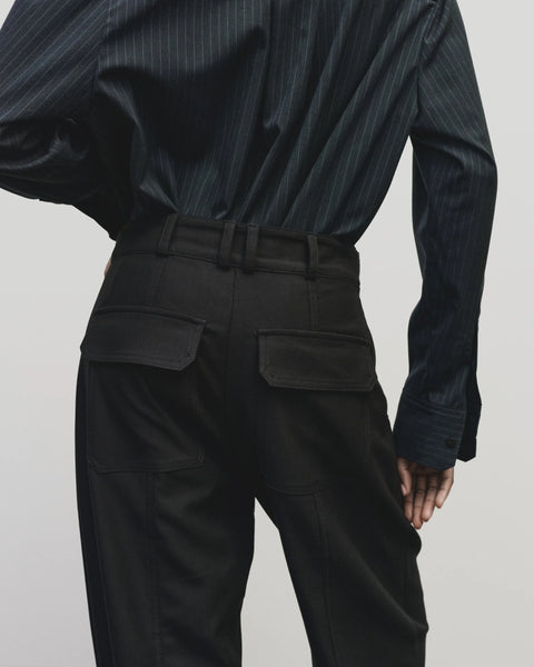 Relaxed fit pants with straight leg and oversized pockets. Buttons on the waist and cuff for adjustability. Navy blue. Trouser by Mijeong Park
