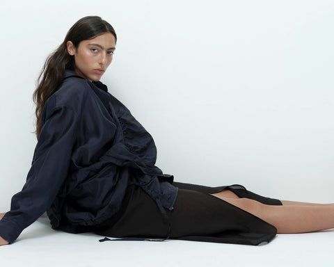 Black organza wrap skirt seated pose sheer layered fabric detail
