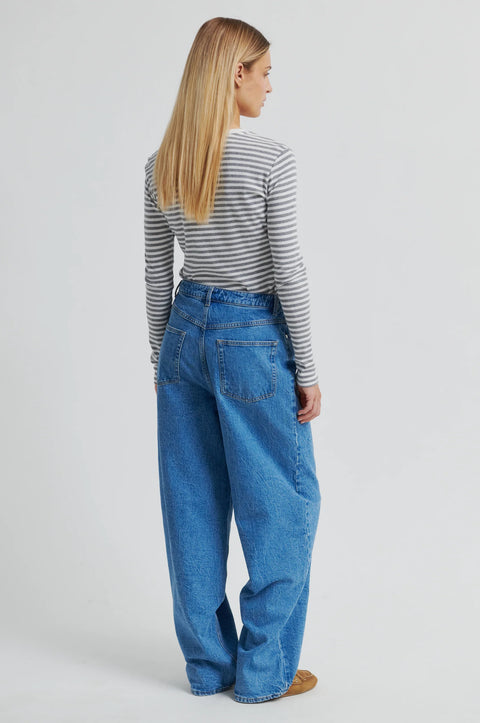 A grey and white striped long sleeve t-shirt by Second Female, featuring a round neckline, twin needle stitching, and a flattering close-fit silhouette crafted from 100% cotton.