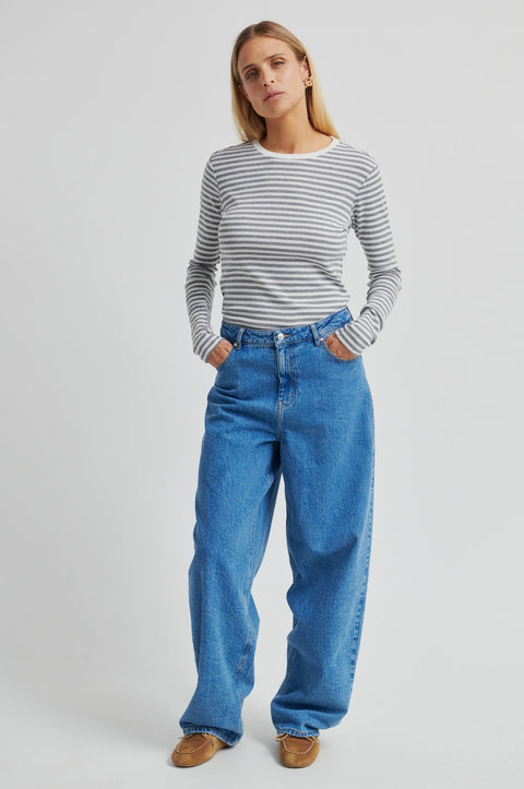 A grey and white striped long sleeve t-shirt by Second Female, featuring a round neckline, twin needle stitching, and a flattering close-fit silhouette crafted from 100% cotton.