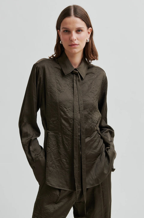 classic blouse cut from crinkle fabric, in dark olive colour. regular collar and concealed button placket, detachable neck tie and side-waist buttons to nip the waist for an adjustable silhouette
