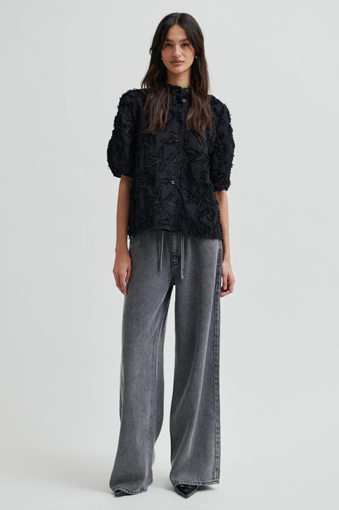 Textured leaf pattern short sleeve cotton sweater in black, button-through placket, and short sleeves with an elastic, ruched detail.
