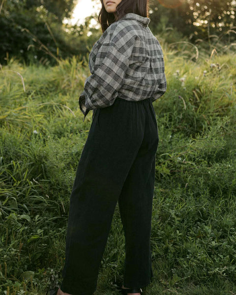 A pair of Thorne Trousers in 100% linen twill featuring a comfortable three-quarter elastic waistband, front pleats, and a vintage-inspired shell button closure.