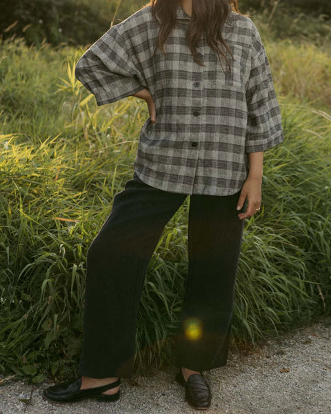 A pair of Thorne Trousers in 100% linen twill featuring a comfortable three-quarter elastic waistband, front pleats, and a vintage-inspired shell button closure.