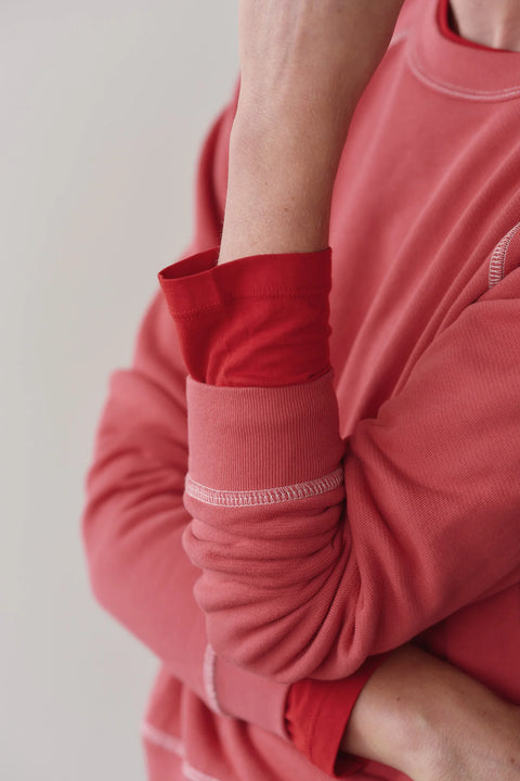 Close-up of creme contrast stitch detail on DONNI raspberry eco terry sweatshirt – organic cotton texture