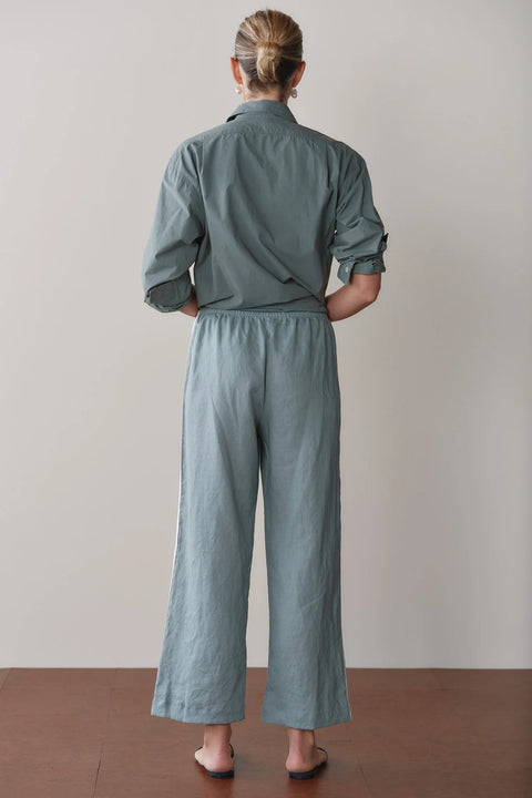 Close-up of DONNI racer stripe linen pant in Sage Green showing elasticated waistband and cropped hem detail